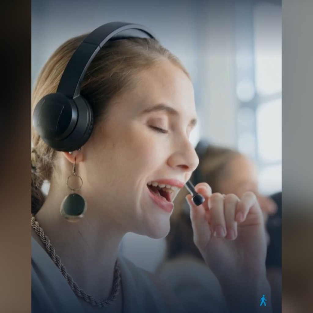 Une conseillère clientèle au casque, souriante, extraite du film Les visages de la qualité